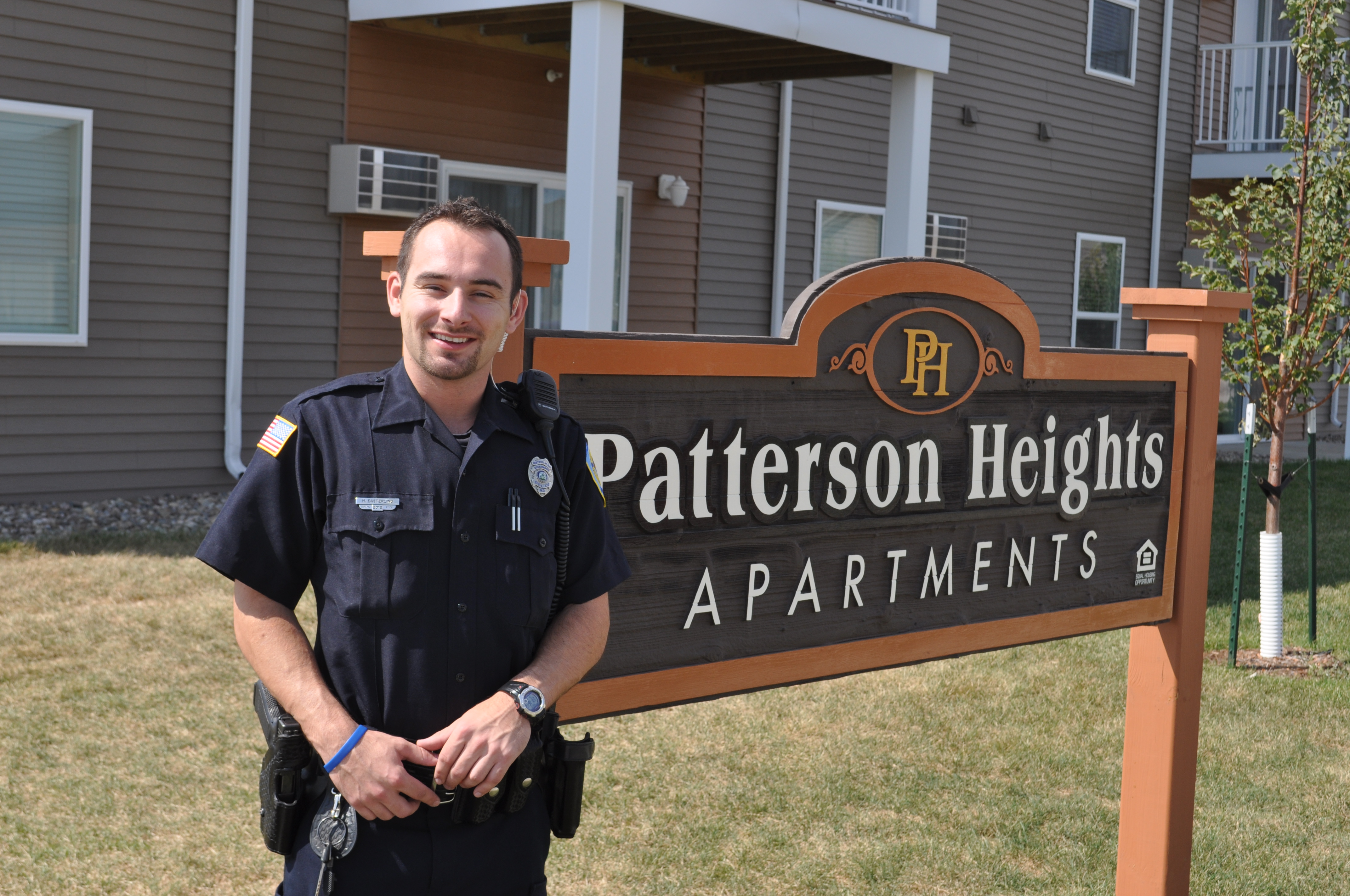 a police officer standing in front of an apartment complex